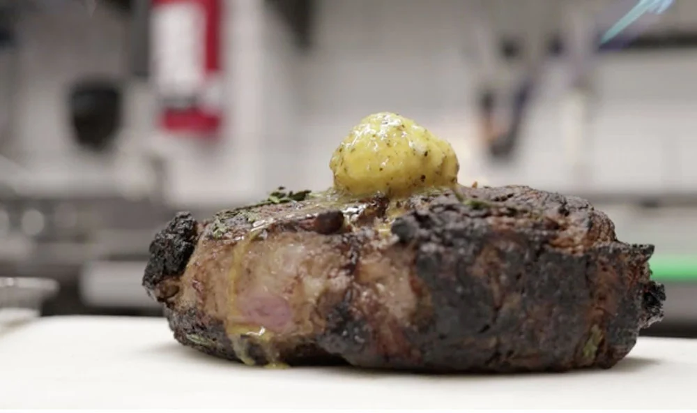 El chef Aaron Mizrahi preparando un rib eye con hueso