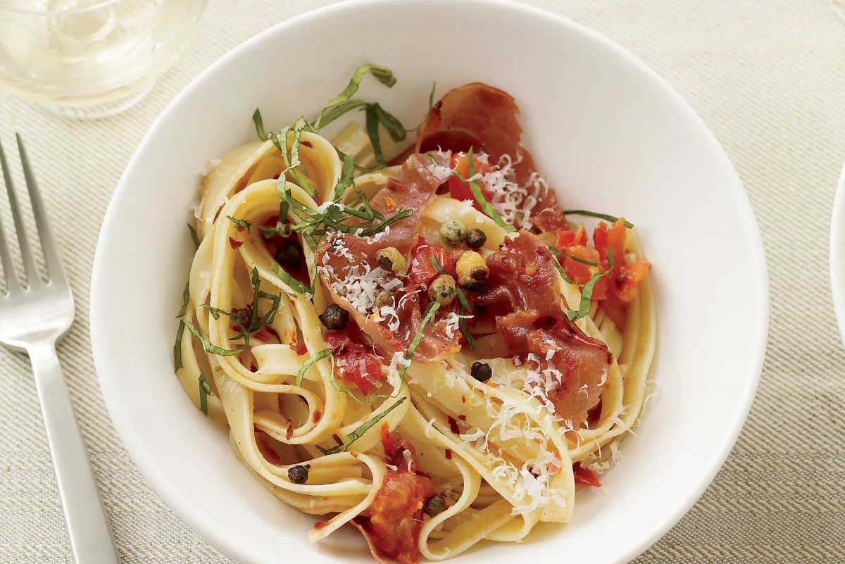 Receta: Fettuccini con prosciutto, jitomate y alcaparras crujientes Receta: Fettuccini con prosciutto, jitomate y alcaparras crujientes