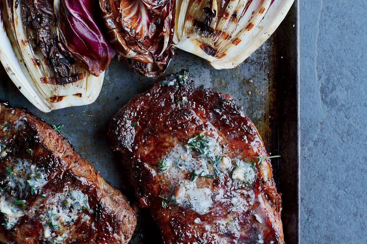 Rib eye a la mantequilla de anchoas y comino, con endivias rojas al grill