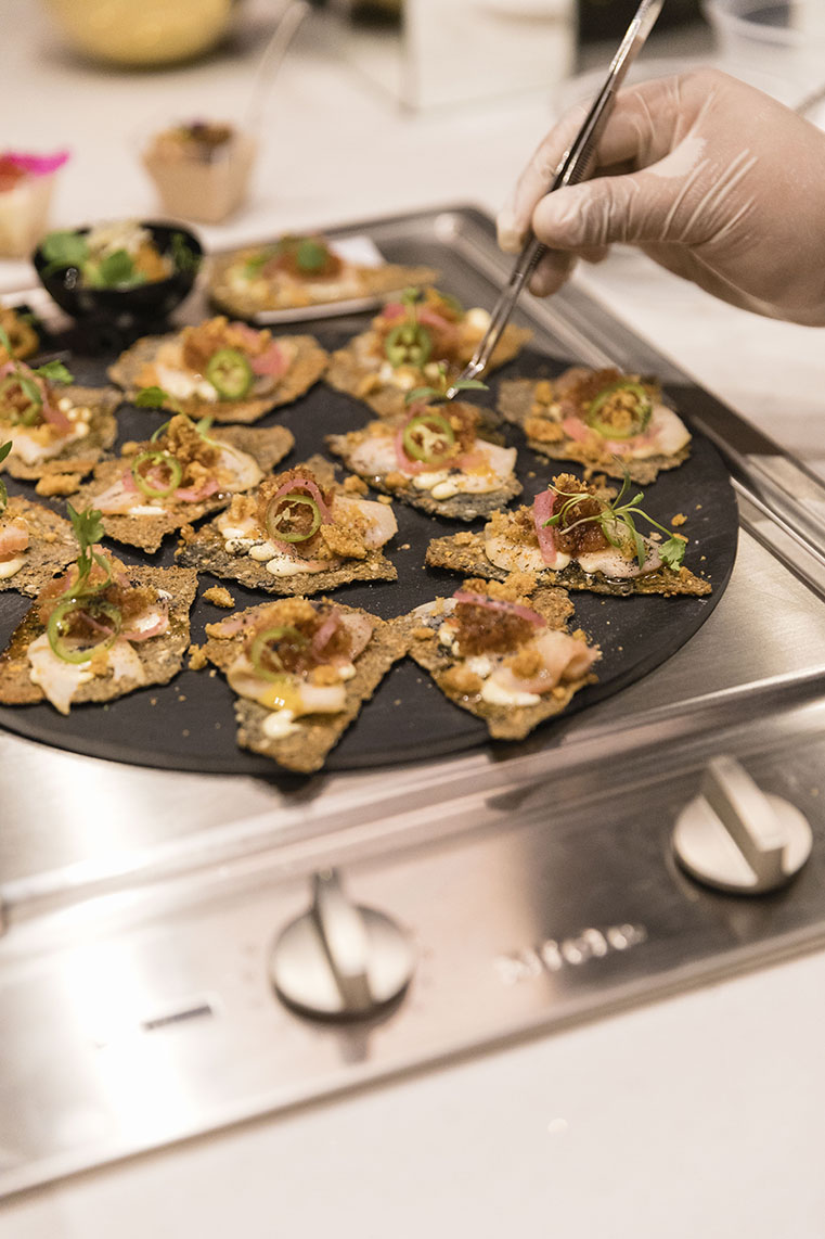  tostada de marlín ahumado servido con aioli de limón eureka, chicharrón prensado y cebolla encurtida.