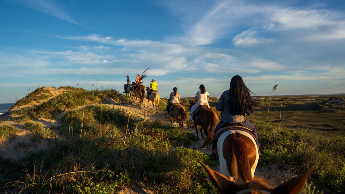 Para las parejas, los tours a caballo son un buen plan para conocer las dunas y la bahía de la Isla del Padre