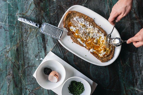 TATEL milanesa de ternera con huevos pochados y trufa rallada.